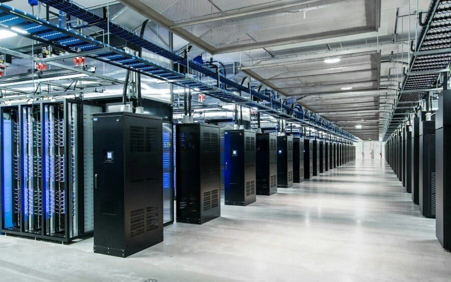 Deretan rack dan utilitas overhead di dalam data center