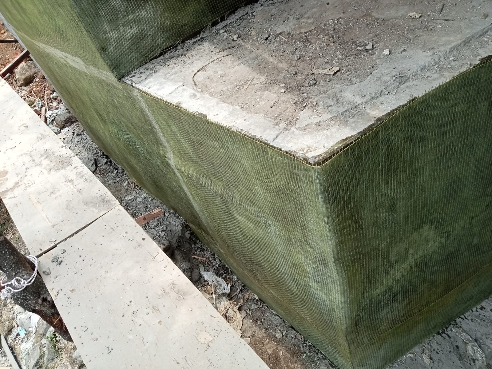 Close-up of FRP sheets following a corner and change of plane on a bridge concrete element