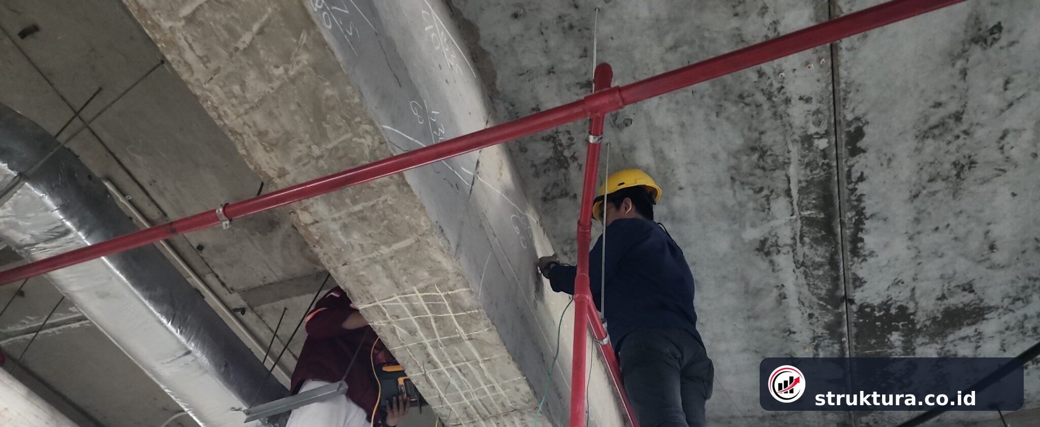 Dua teknisi menempatkan transducer UPV pada sisi berhadapan balok beton