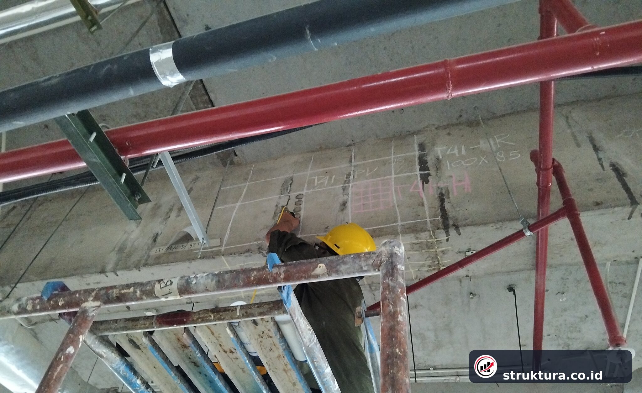 Teknisi menandai grid test point UPV pada sisi balok beton