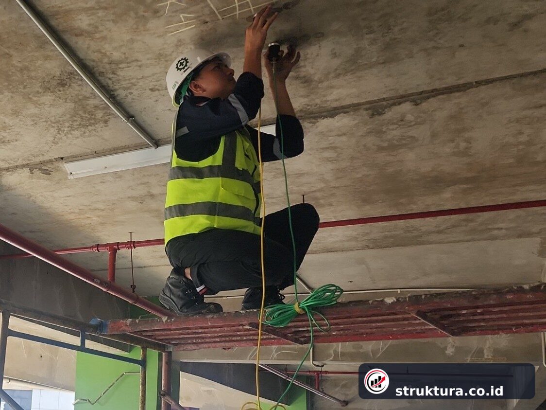 Teknisi menempatkan dua transducer UPV pada test point di permukaan bawah pelat beton
