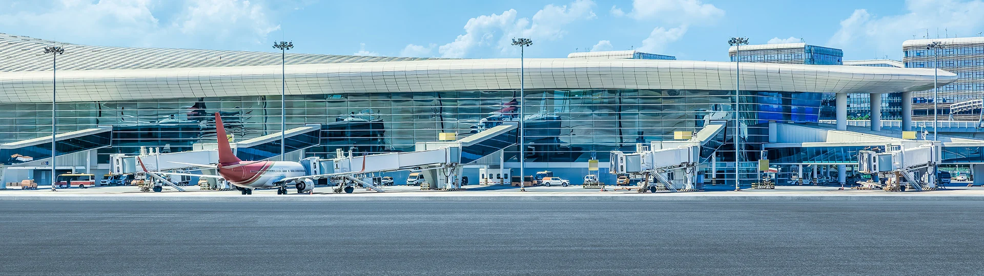 Pesawat di depan gedung terminal dengan hamparan perkerasan apron bandara