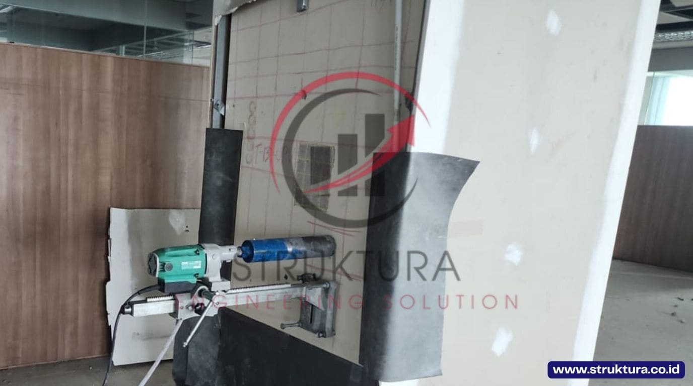 Mesin core drill beton terpasang pada elemen struktur sebelum pengambilan sampel inti beton
